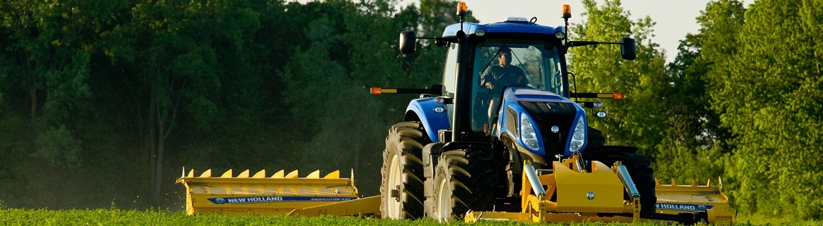 New Holland Tractor tractor ploughing a green field for sowing